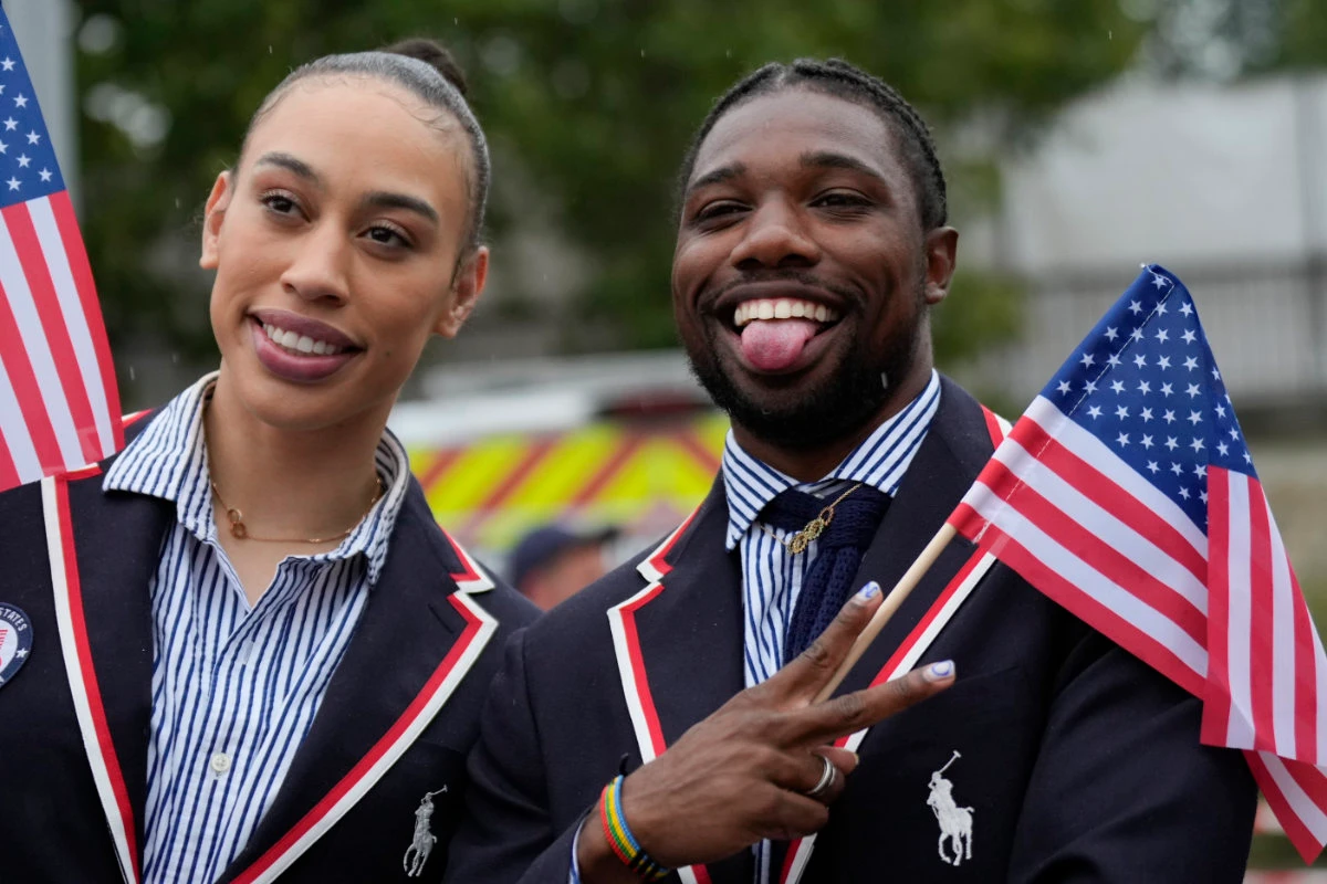 Noah Lyles, right, of the US, poses for photos while traveling along the Seine River in Paris during the opening ceremony of the 2024 Summer Olympics Friday. (AP)