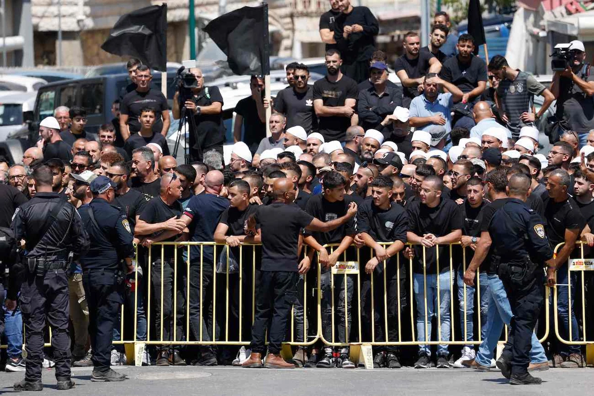Israeli security hold back demonstrators during a visit by the Israeli prime minister two days after a rocket crashed, killing 12 youngsters in the Druze village of Majdal Shams in the Israeli annexed Golan Heights. (AFP)
