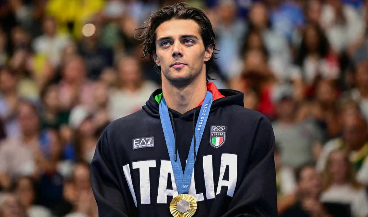 Gold medallist Italy's Thomas Ceccon poses on the podium of the men's 100m backstroke swimming event during the Paris 2024 Olympic Games at the Paris La Defense Arena in Nanterre, west of Paris, on July 29, 2024. (AFP)