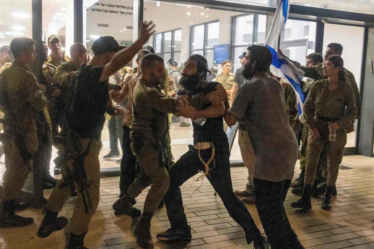 Israeli soldiers clash with right wing protesters, after they broke into the Bayt Lid army base over the detention for questioning of military reservists who were suspected of abuse of a detainee. (Reuters)
