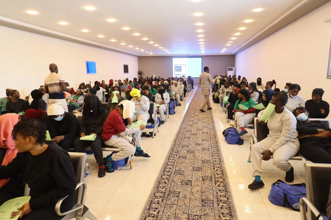 Irregular Nigerian migrants, who voluntarily agreed to be deported by home, sit waiting at the anti-migration bureau, tasked with coordinating deportations of foreigners who are in the country illegally, befotre departing to Mitiga International Airport in Tripoli on Jul. 30, 2024. (AFP)