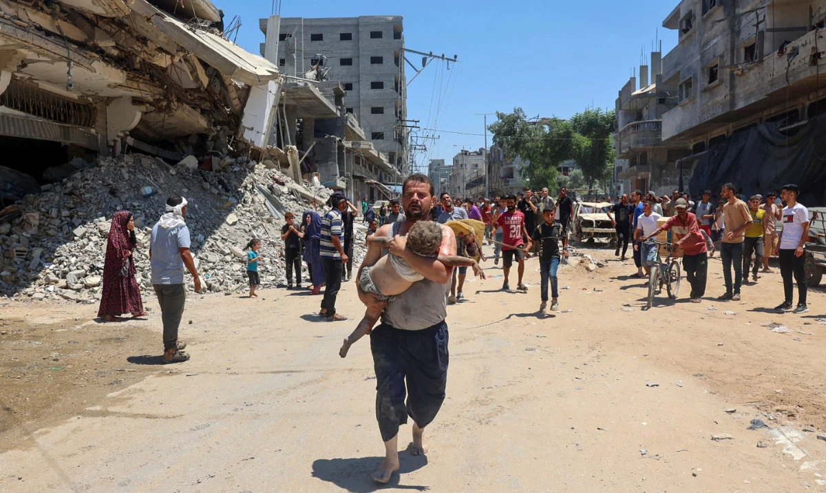 People carry children injured during Israeli bombardment as people flee at the Al-Bureij refugee camp in the Gaza Strip. (AFP)