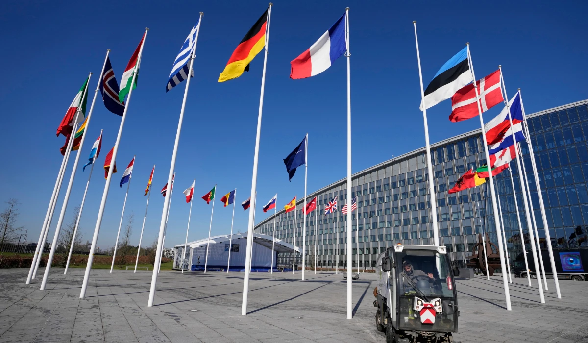 An empty flagpole stands between the national flags of France and Estonia outside NATO headquarters in Brussels. (AP file photo)