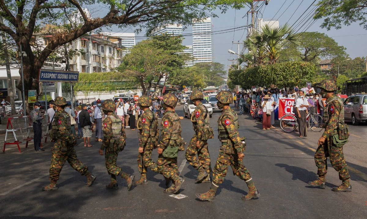 Soldiers cross a street as people gather to protest against the military coup, in Yangon, Myanmar. (Reuters/File)