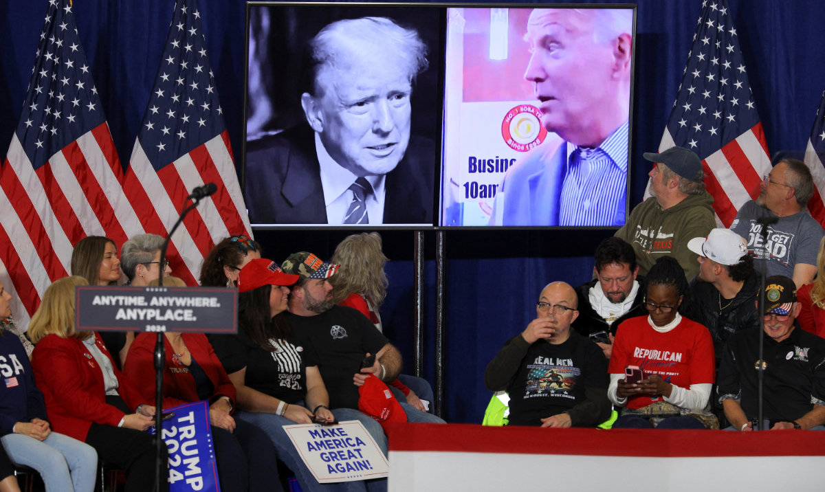 Pictures of Joe Biden and Republican presidential candidate Donald Trump are seen on a screen during campaign rally. (Reuters)