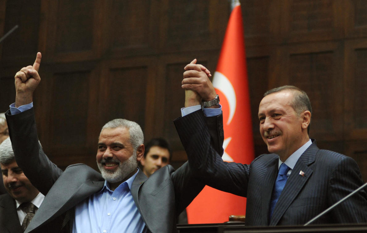FILE photo of Hamas Prime minister Ismail Haniya (L) and his Turkish counterpart Recep Tayyip Erdogan salute together the lawmakers of Erdogan’s Islamic-rooted Justice and Development Party at the Parliament in Ankara on January 3, 2012. (AFP)