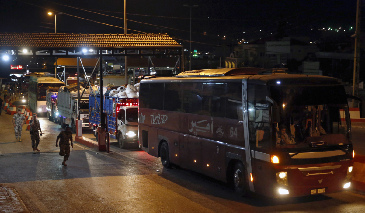 A convoy of buses and trucks carry Syrian refugees with their belongings cross into Syria at the Lebanese border crossing point of Masnaa, in Bekaa Valley, Lebanon, July 28, 2018. (AP)