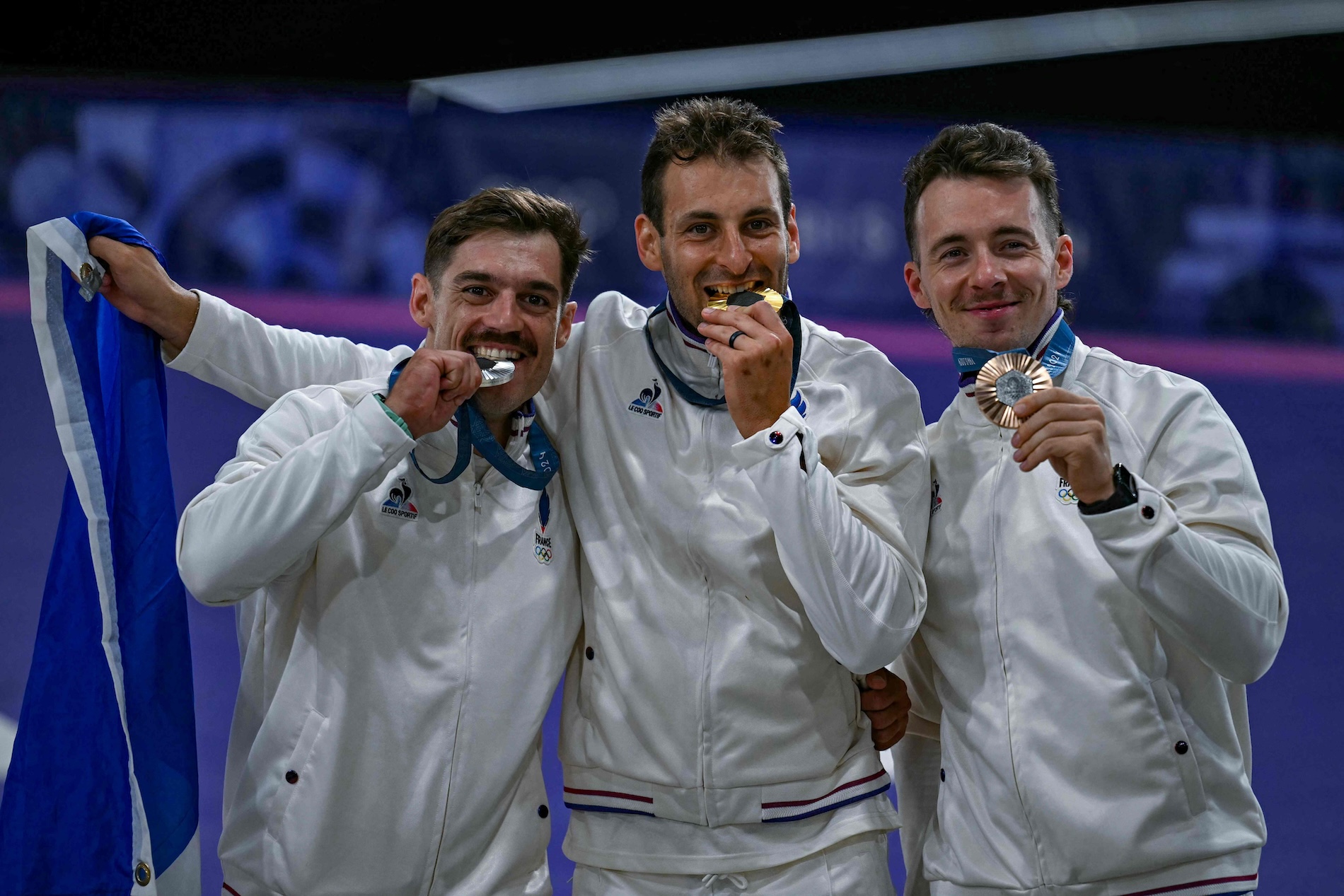Gold medalist France's Joris Daudet (C), runner up France's Sylvain Andre (L) and bronze winner France's Romain Mahieu (R) celebrate on the podium after competing in the men's cycling BMX Racing finals during the Paris 2024 Olympic Games in Saint-Quentin-en-Yvelines, on Aug. 2, 2024. (AFP)