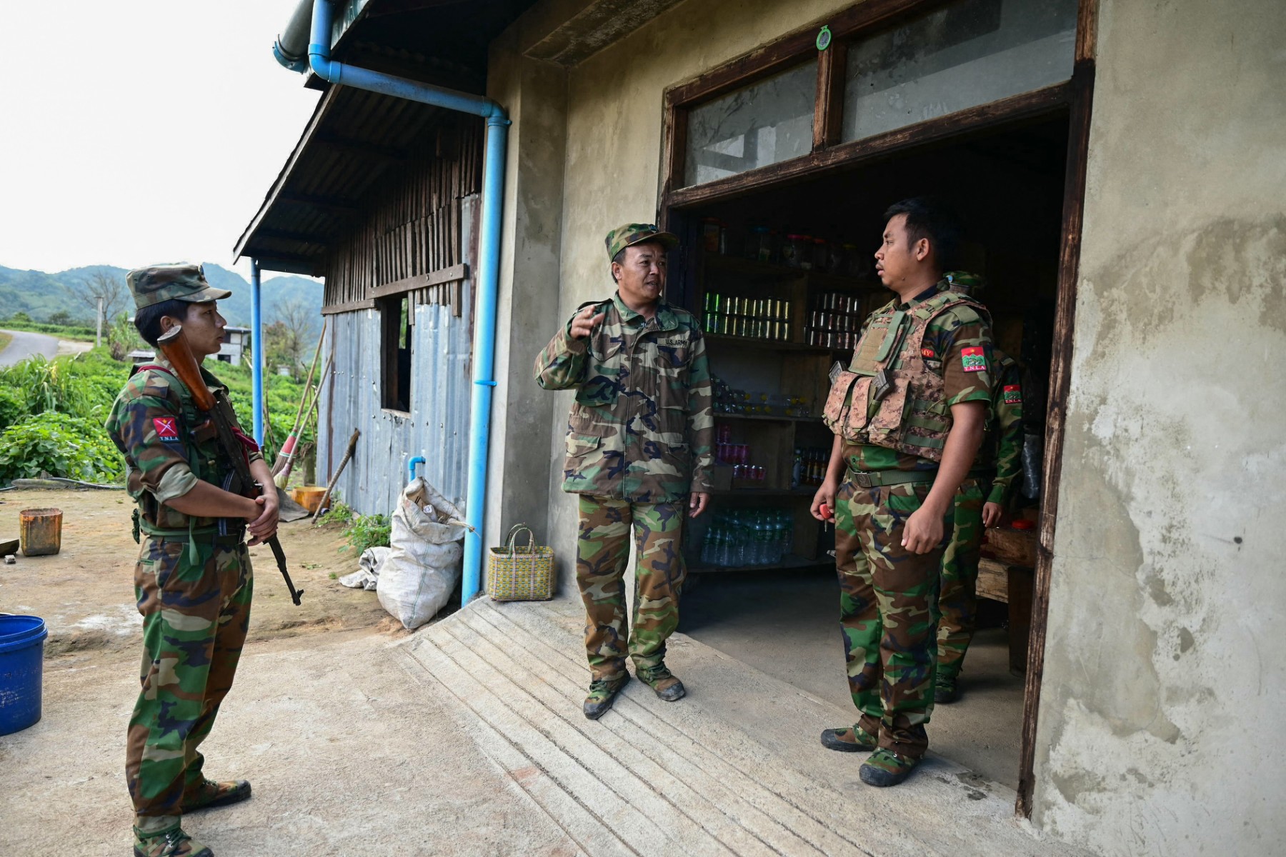 This photo taken on December 12, 2023 shows ethnic minority armed group Ta'ang National Liberation Army (TNLA) spokesman Tar Aik Kyaw (C) talking with soldiers at a checkpoint amid clashes with Myanmar's military near Namhsan Township in northern Shan State. (AFP)