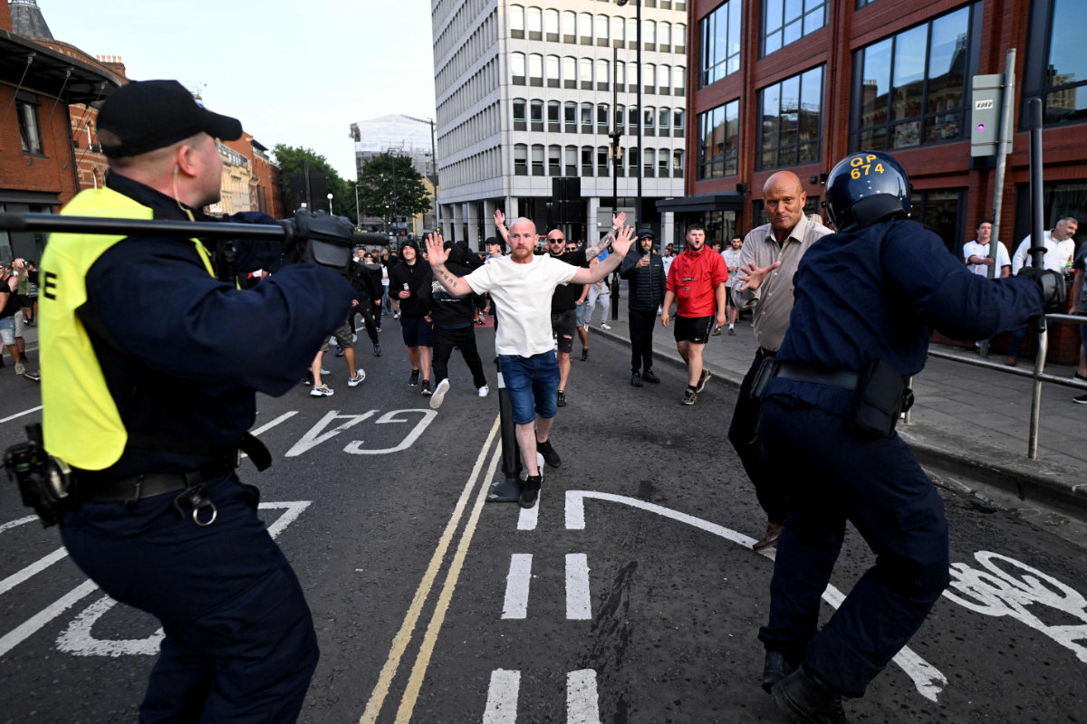 Riot police face protesters in Bristol, southern England, on August 3, 2024 during the 'Enough is Enough' demonstration held in reaction to the fatal stabbings in Southport on July 29. (AFP)