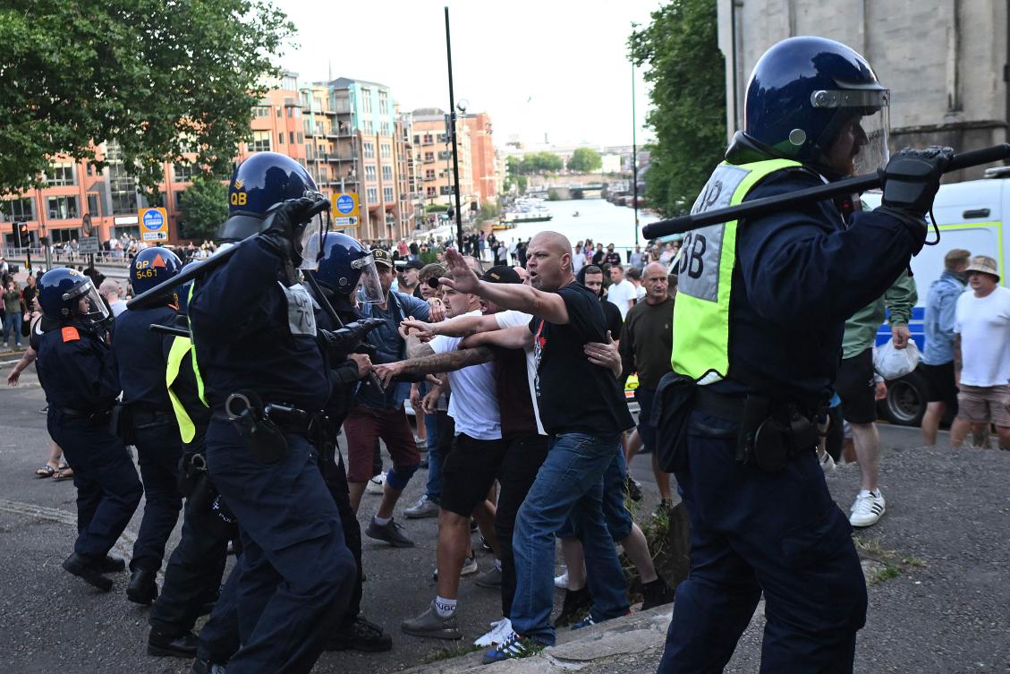 Police officers face off with protesters during the 'Enough is Enough' demonstration called by far-right activists in Bristol on August 3, 2024. Far-right protesters clashed with British police during tense rallies as unrest linked to disinformation about a mass stabbing that killed three young girls spread across the UK. (AFP)