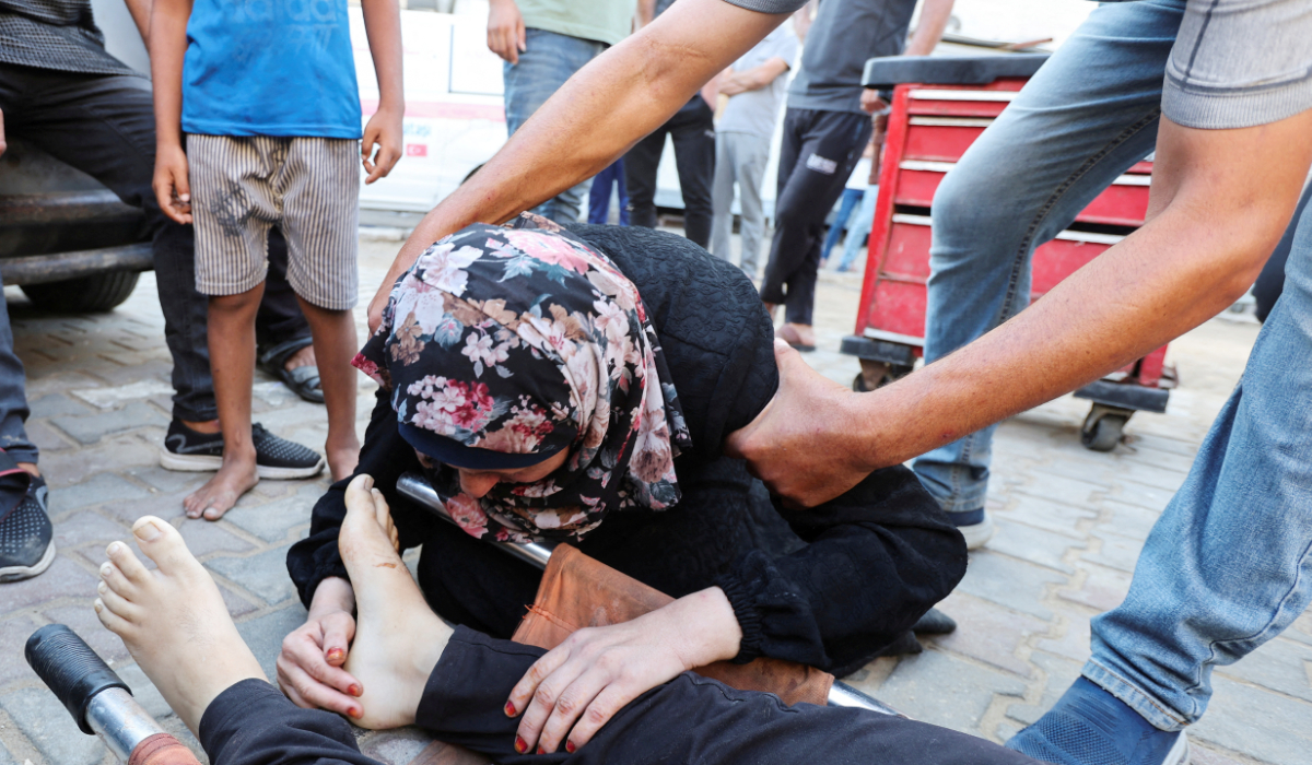 A mourner reacts next to the body of Palestinian Ismail Nofal, who was killed in an Israeli strike on a tent camp for displaced people, amid the Israel-Hamas conflict, at Al Aqsa Martyrs hospital in Deir Al-Balah in the central Gaza Strip, August 4, 2024. (REUTERS)