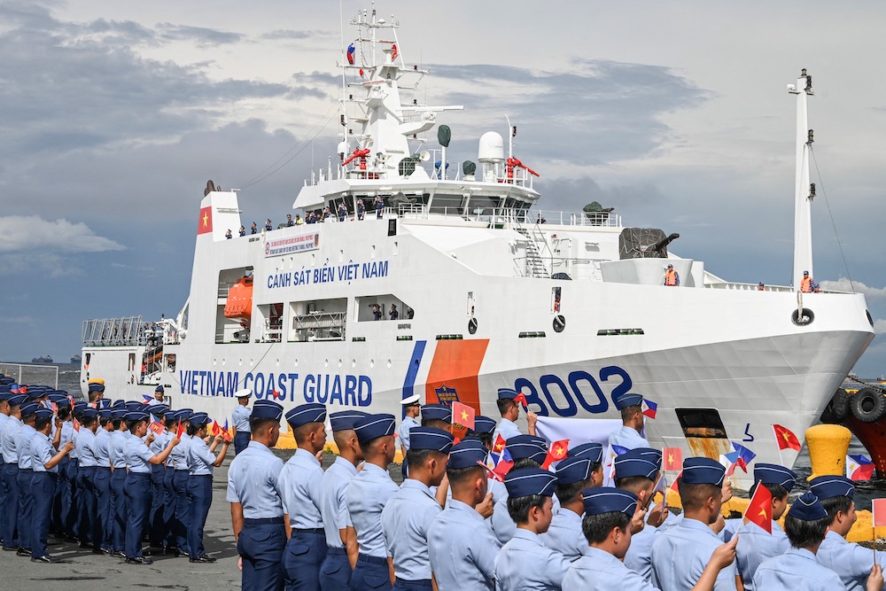 Philippine Coast Guard personnel welcome Vietnam’s 90-meter ship CSB 8002 as it arrive at the port of Manila on Monday for a five-day port call on Aug. 5, 2024. (AFP)
