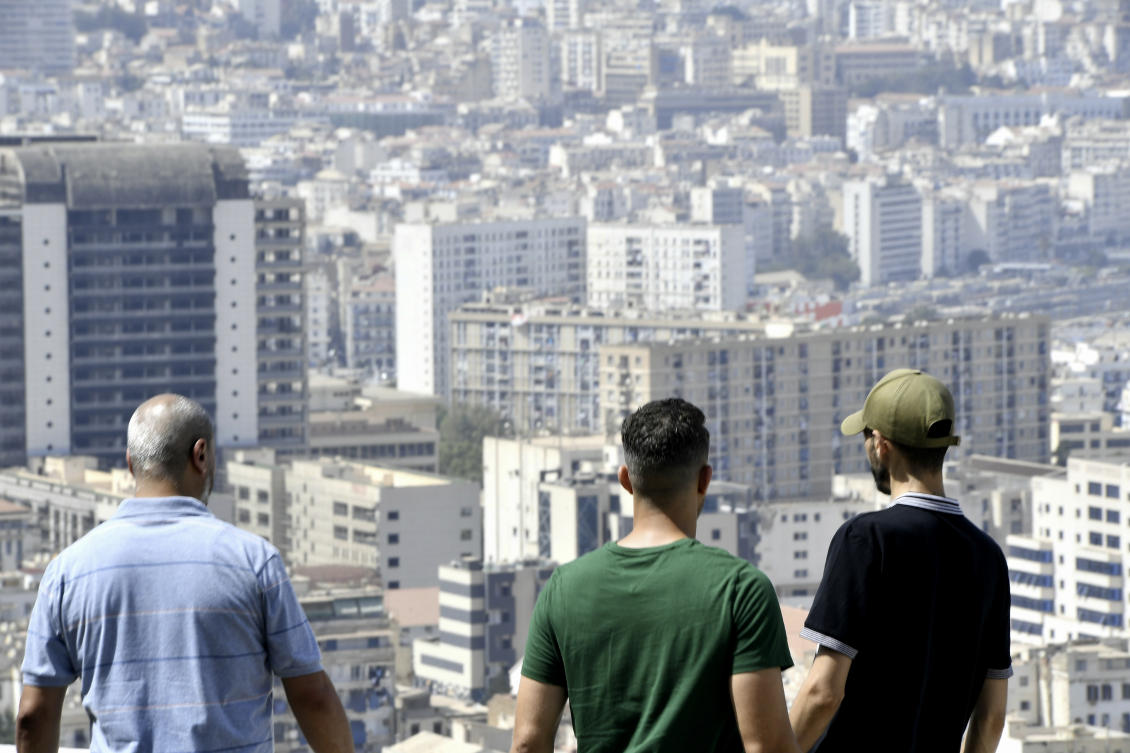 Youths look at the view of the city from top of a building in Algiers, Algeria, Monday, July 29, 2024. (AP)