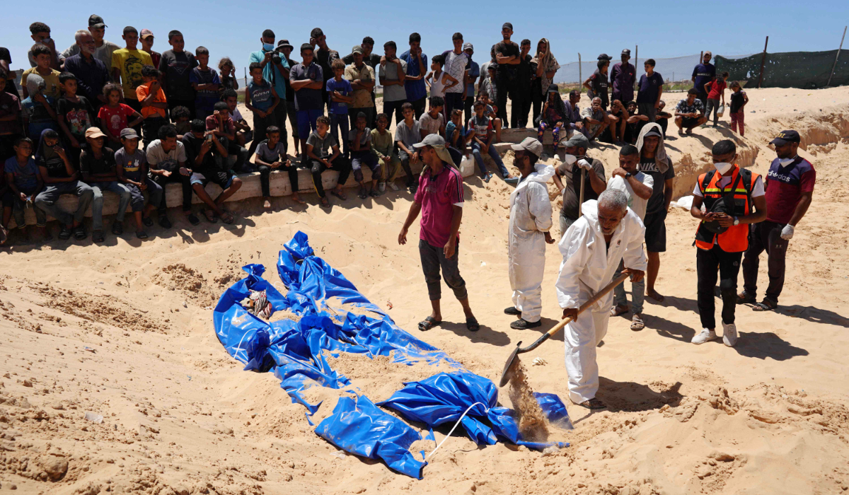 Men burry bodies that were taken and later released by Israel during a mass funeral at a cemetery in Khan Yunis in the southern Gaza Strip on August 5, 2024, amid the ongoing conflict between Israel and the Palestinian Hamas militant group. (AFP)