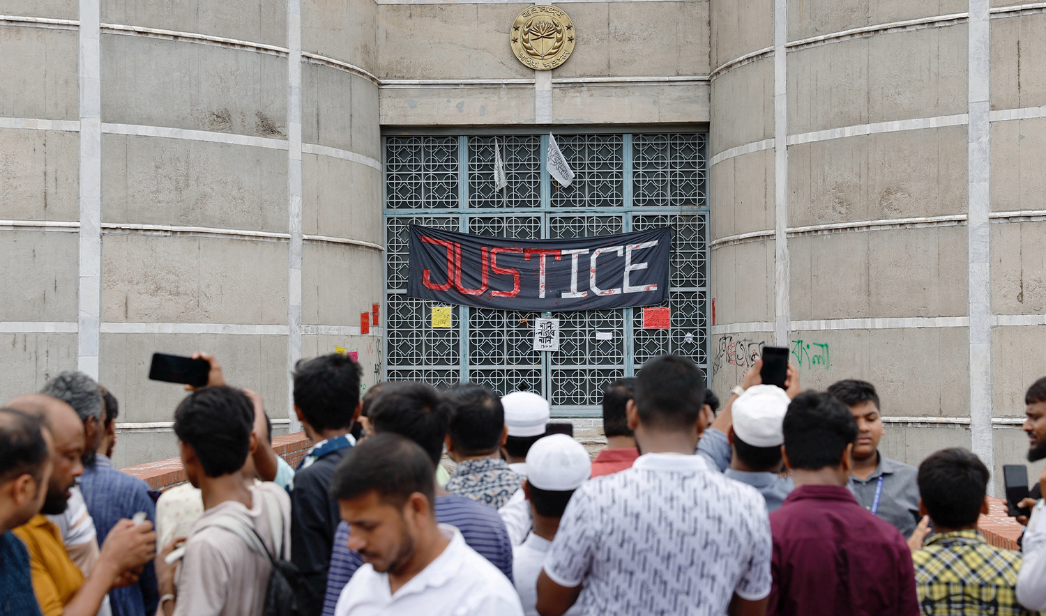 People gather at the entrance of the Parliament Building a day after the resignation of Bangladeshi Prime Minister Sheikh Hasina, in Dhaka, Bangladesh, on August 6, 2024. (REUTERS)
