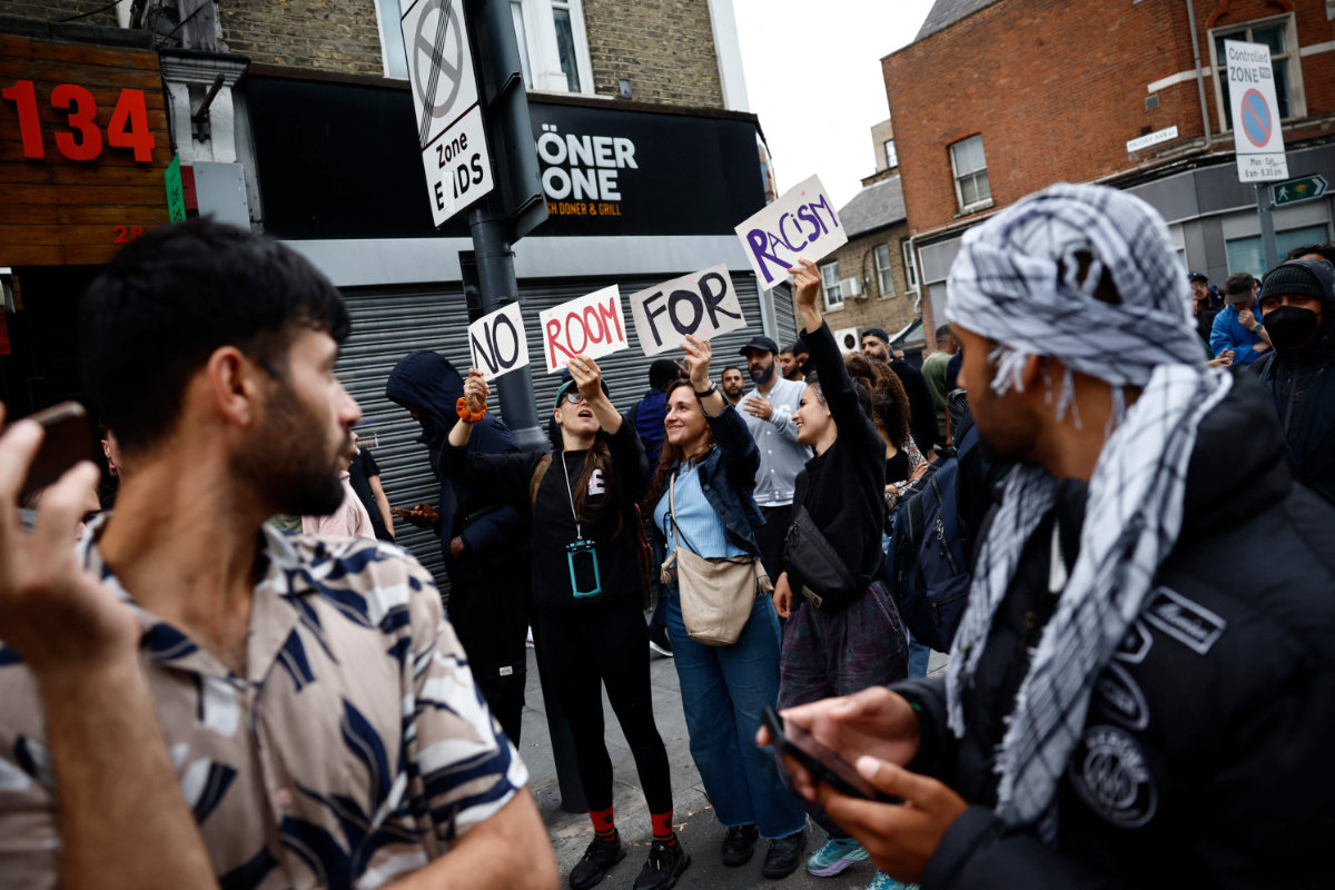 People hold a banner reading "Refugees welcome" during a counter demonstration against an anti-immigration protest called by far-right activists in Birmingham, central England, on August 7, 2024. (AFP)