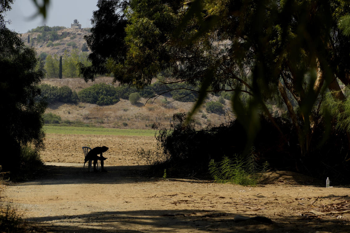 A refugee man sits on a chair under trees at a camp inside the UN controlled buffer zone that divide the north part of the Turkish occupied area from the south Greek Cypriots at Aglantzia area in the divided capital Nicosia on Aug. 9, 2024. (AP)