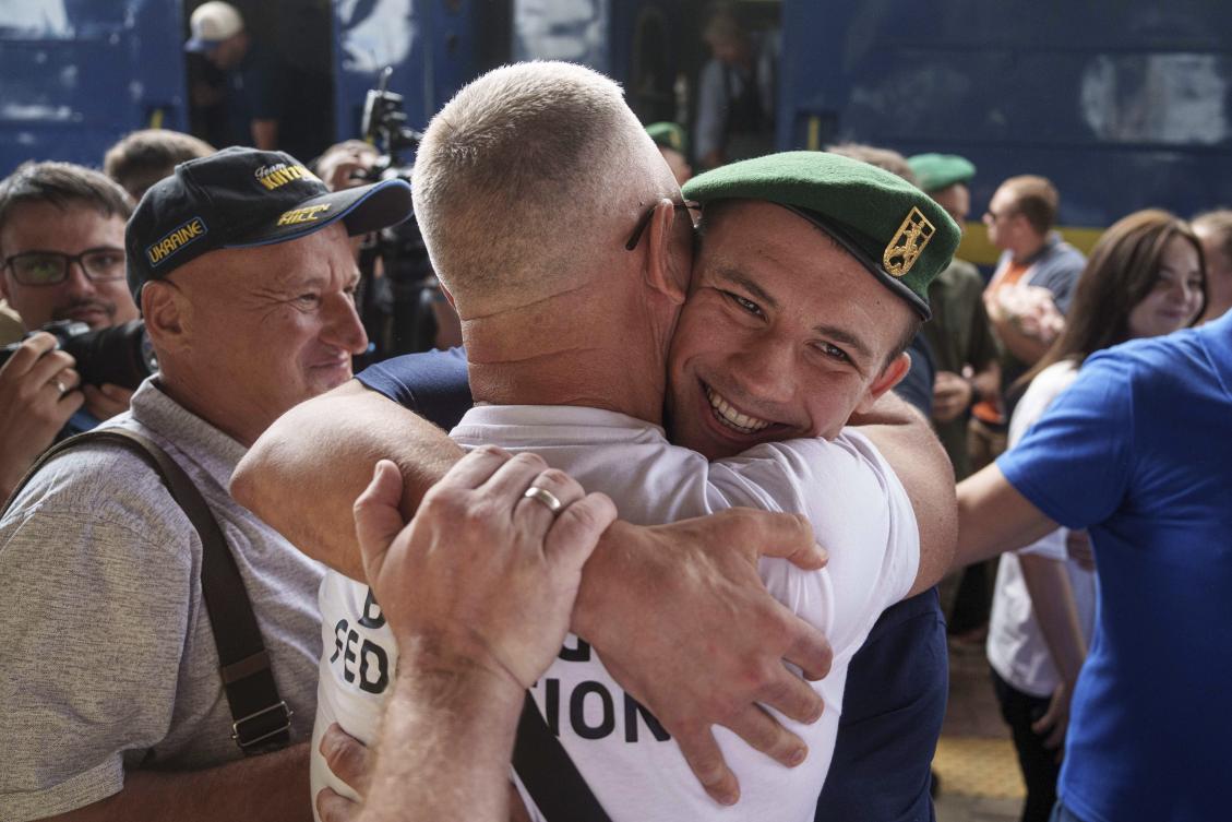 Oleksandr Khyzhniak, Ukraine’s Gold medalist of 2024 Summer Olympics for the men’s 80 kg boxing, hugs his friend after arriving at the train station in Kyiv on Aug. 10, 2024. (AP)