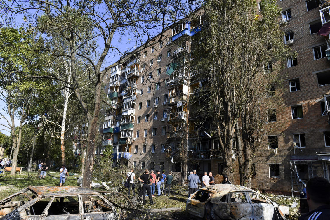 People gather at an apartment building damaged after shelling by the Ukrainian side in Kursk, Russia. (AP)
