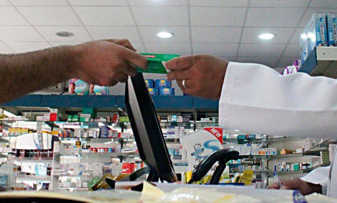 A man pays for medicine at a hospital pharmacy in Khobar city in Dammam, in this May 21, 2013. (File/Reuters)