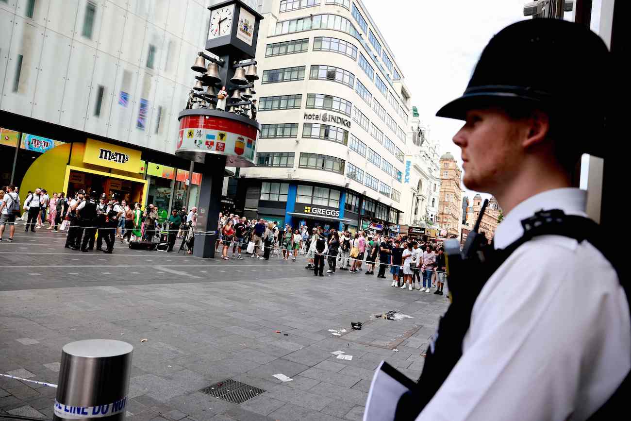 A police officer stands by a cordoned off area in Leicester square, London after a woman and an 11-year-old girl were hospitalised after being stabbed. (AFP)