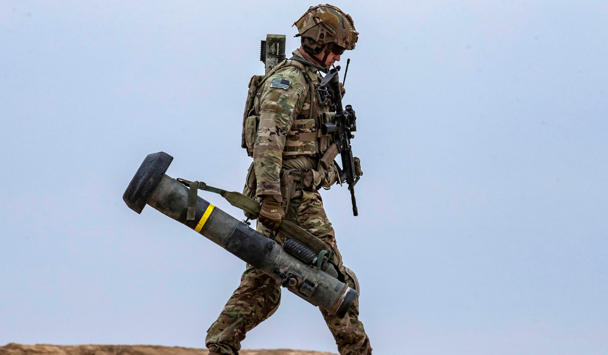 A US soldier walks with a javelin surface-to-air missile launcher during a joint military exercise between the Syrian Democratic Forces (SDF) and the US-led international coalition against the Daesh group, in the countryside of Deir Ezzor in northeastern Syria on December 7, 2021. (AFP)