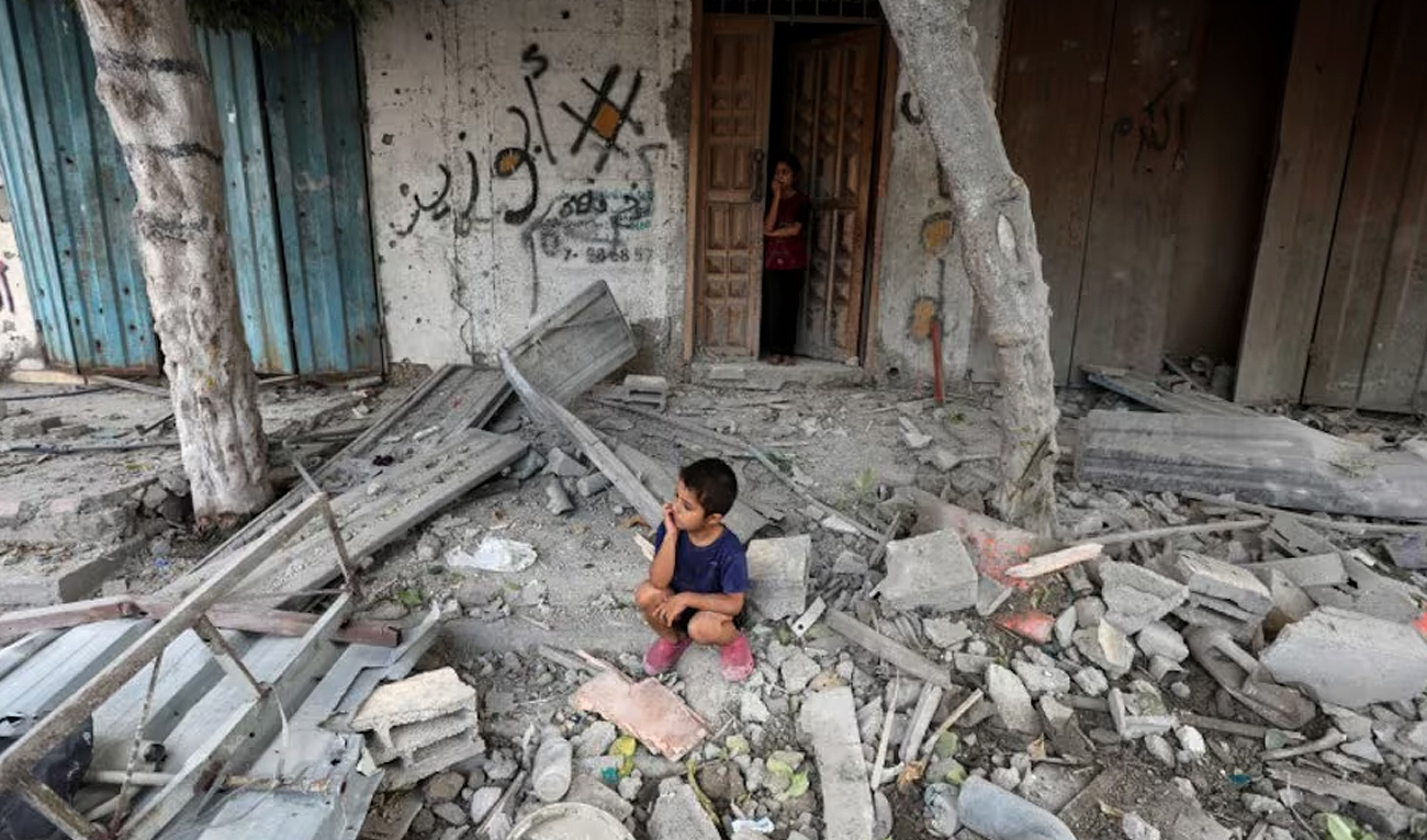 A Palestinian boy sits at the site of an Israeli strike on a house, amid the Israel-Hamas conflict, in Maghazi refugee camp in the central Gaza Strip, August 14, 2024. (REUTERS)