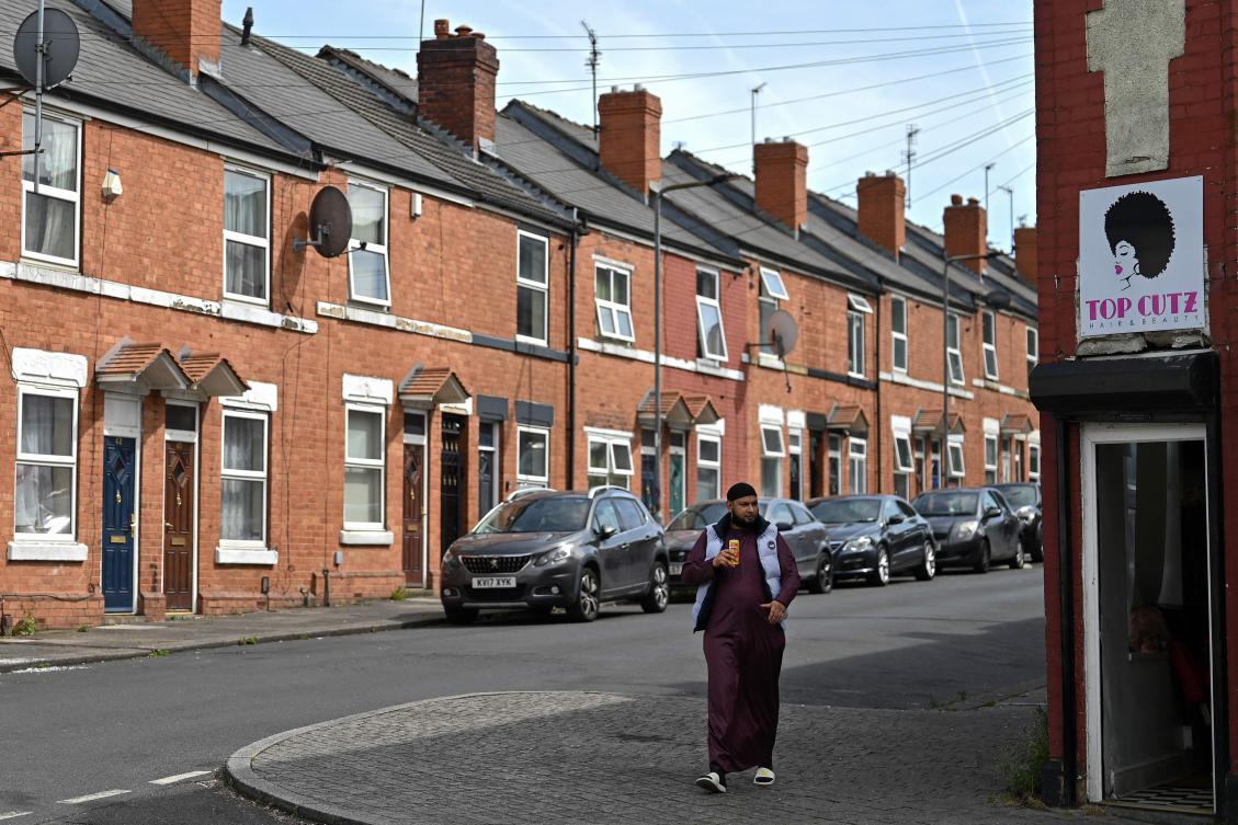 A person walks along on the footpath by a row of houses in the Eastwood area of Rotherham, northern England on August 13, 2024. (AFP)