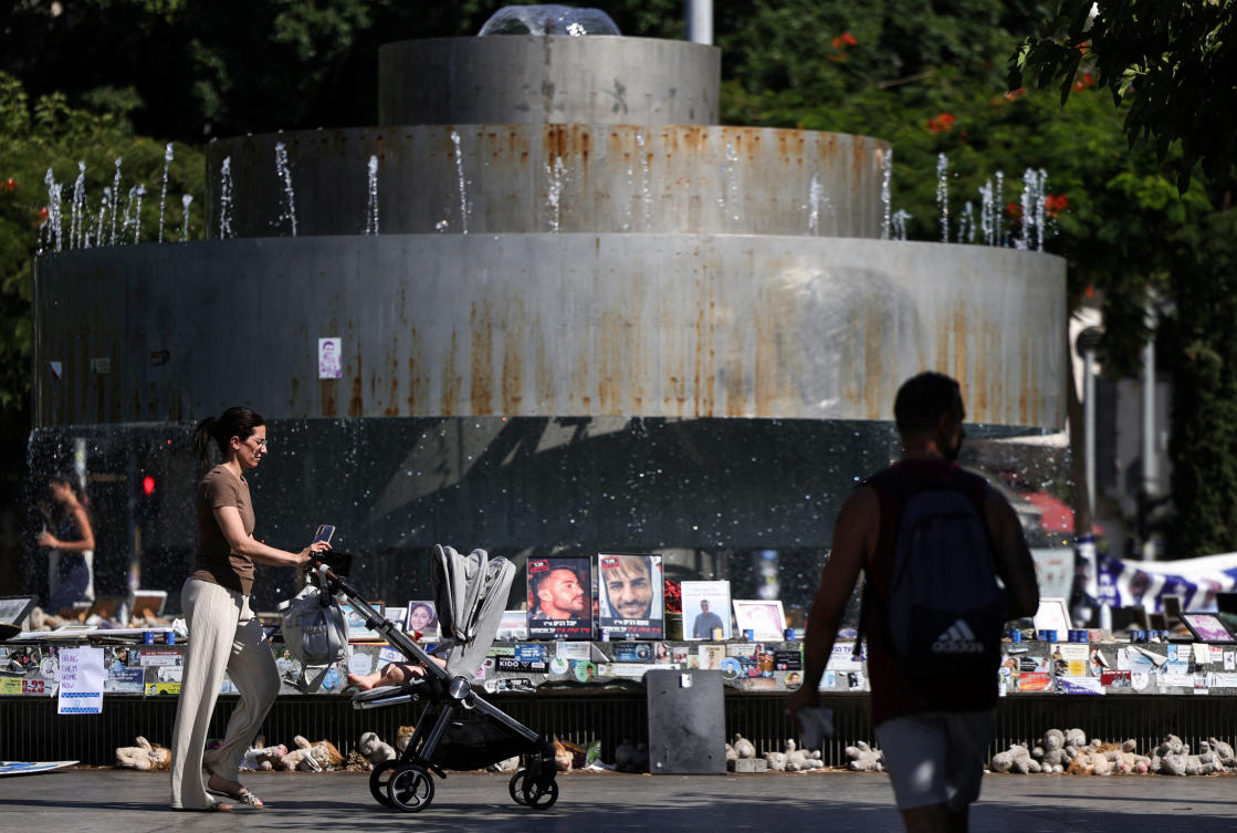 People walk next to memorial pictures of hostages kidnapped during the deadly October 7 attack on Israel by Hamas, amid the ongoing Israel-Hamas conflict, in Tel Aviv, Israel. (File/Reuters)