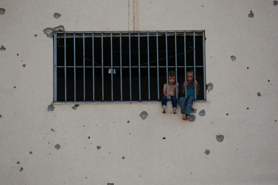 Palestinian children sit on a whindow sill at the Asdaa central prison facility which has become a shelter for displaced people in Khan Yunis in the southern Gaza Strip amid the ongoing conflict between Israel and the Hamas militant group. (File/AFP)