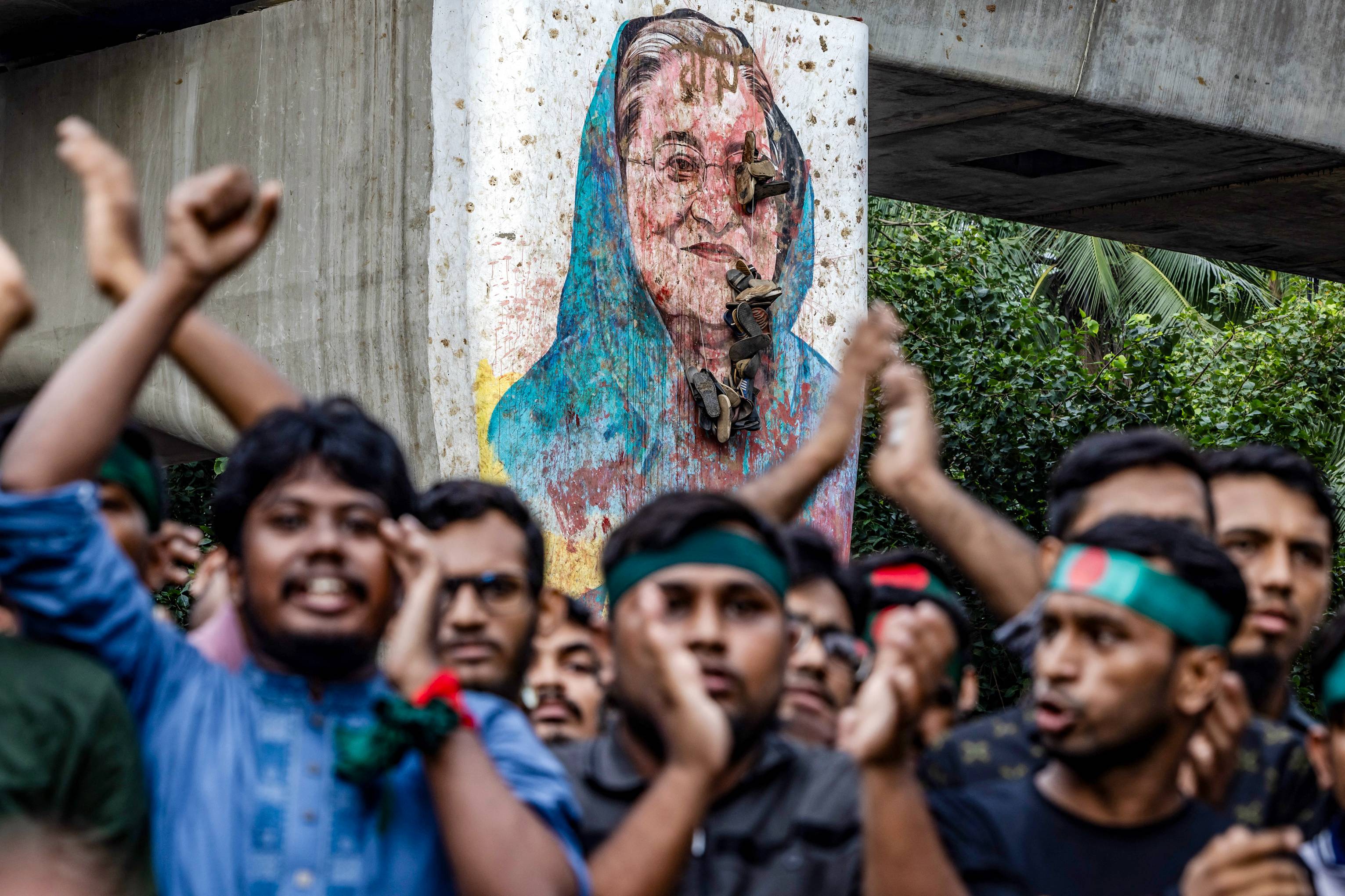 Students chant slogans near a vandalized mural of Bangladesh's ousted Prime Minister Sheikh Hasina, during a protest demanding accountability and trial against Hasina in Dhaka. (AFP)