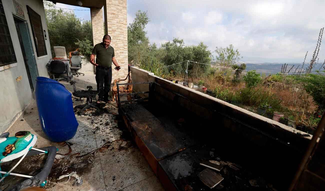 A man checks the damage in his house, a day after an attack by Jewish settlers on the village of Jit near Nablus in the occupied West Bank that left a 23-year-old man dead and others with critical gunshot wounds, on August 16, 2024. (AFP)