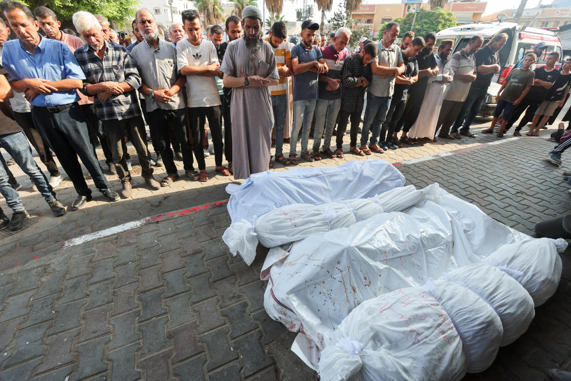 Mourners pray next to the bodies of Palestinians killed in Israeli strikes at Al-Aqsa Martyrs Hospital in Deir Al-Balah in the central Gaza Strip, on Aug. 14, 2024. (Reuters)