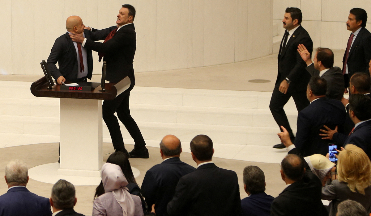 Turkey's AK Party lawmaker Alpay Ozalan scuffles with Workers' Party of Turkey (TIP) lawmaker Ahmet Sik, who was speaking during an extraordinary meeting of the Turkish parliament to discuss jailed opposition lawmaker Can Atalay's return to the assembly, in Ankara, Turkey August 16, 2024. (REUTERS)