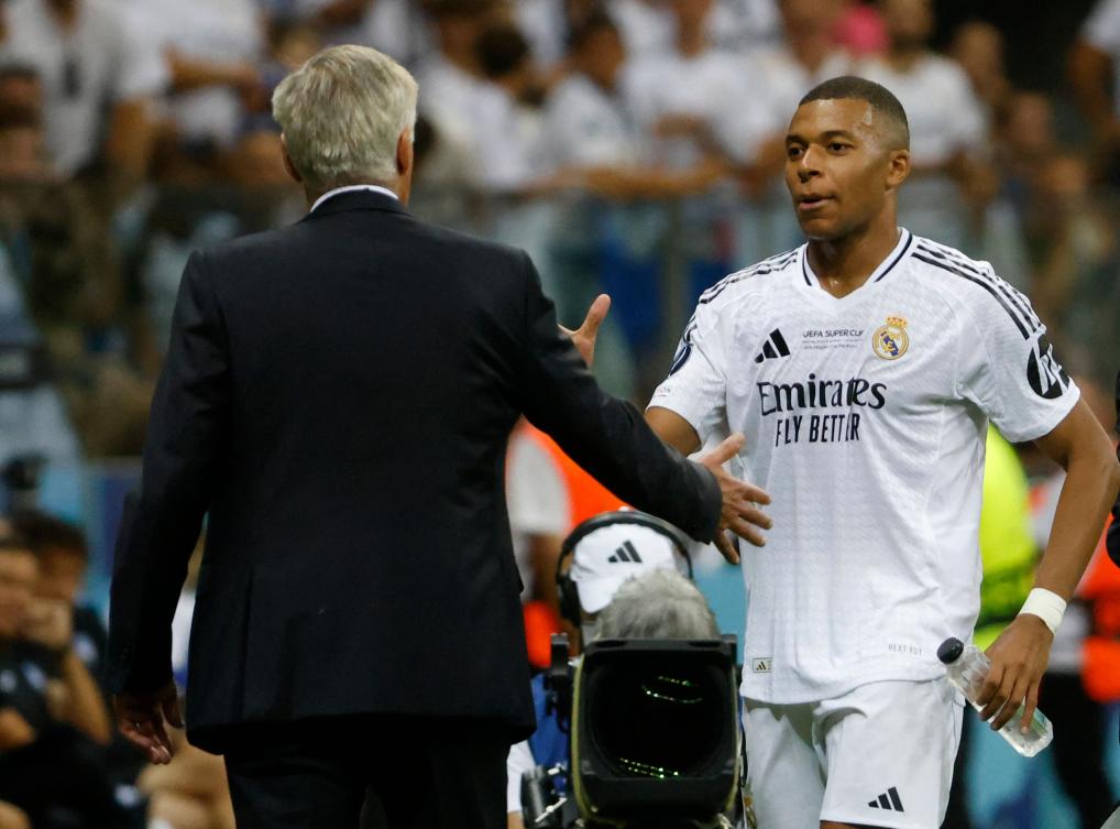 Real Madrid’s French forward Kylian Mbappe shakes hands with Italian coach Carlo Ancelotti after being substituted during their UEFA Super Cup match against Atalanta BC in Warsaw, on Aug. 14, 2024. (AFP)