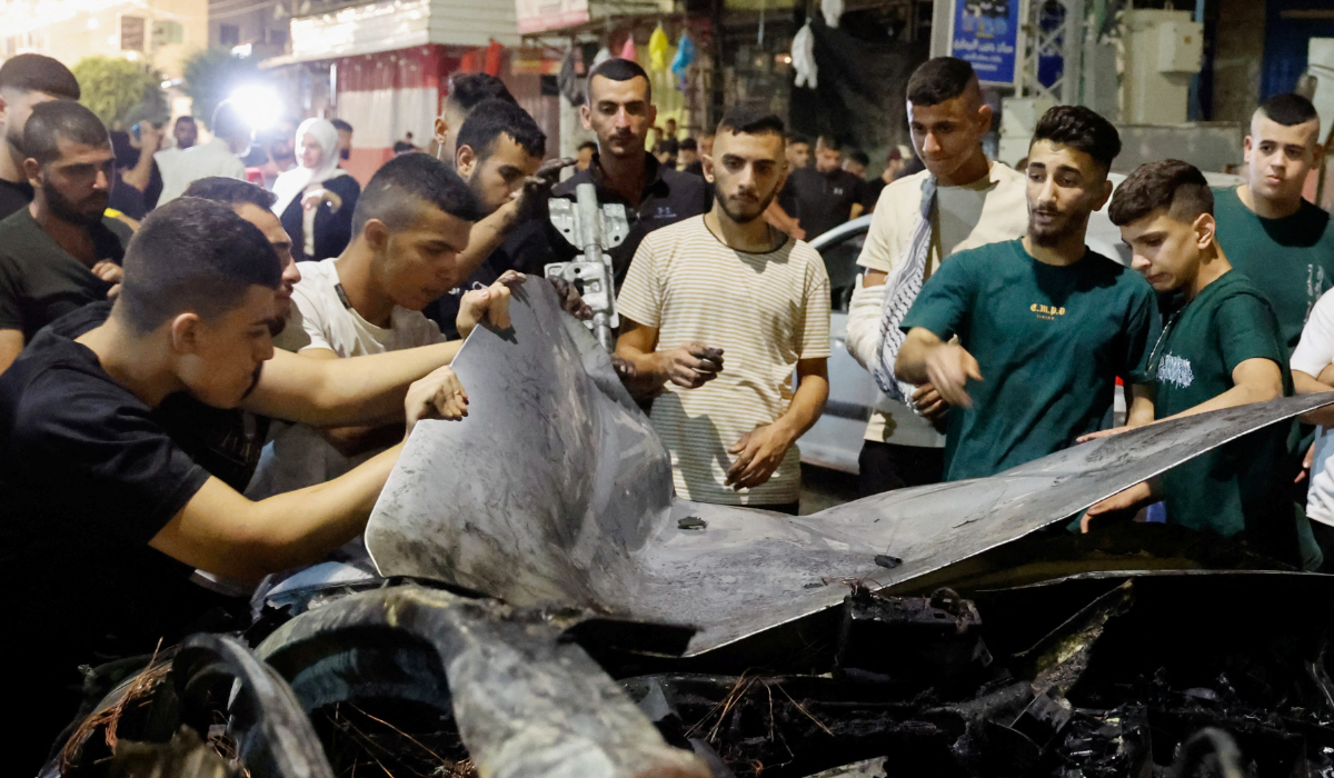 Palestinians inspect a car damaged in an Israeli airstrike, in Jenin, in the Israeli-occupied West Bank, August 17, 2024. (REUTERS)