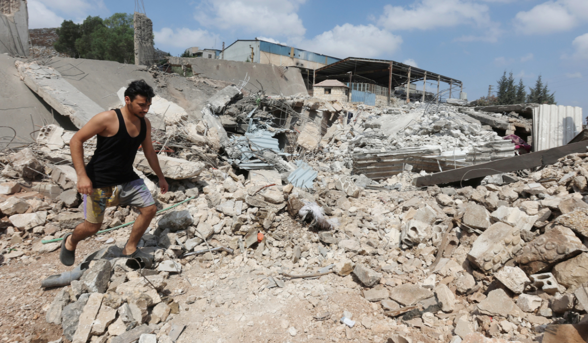 A man walks on rubble of a damaged site in the aftermath of an Israeli airstrike in Al-Kfour, Nabatieh, southern Lebanon. (Reuters)
