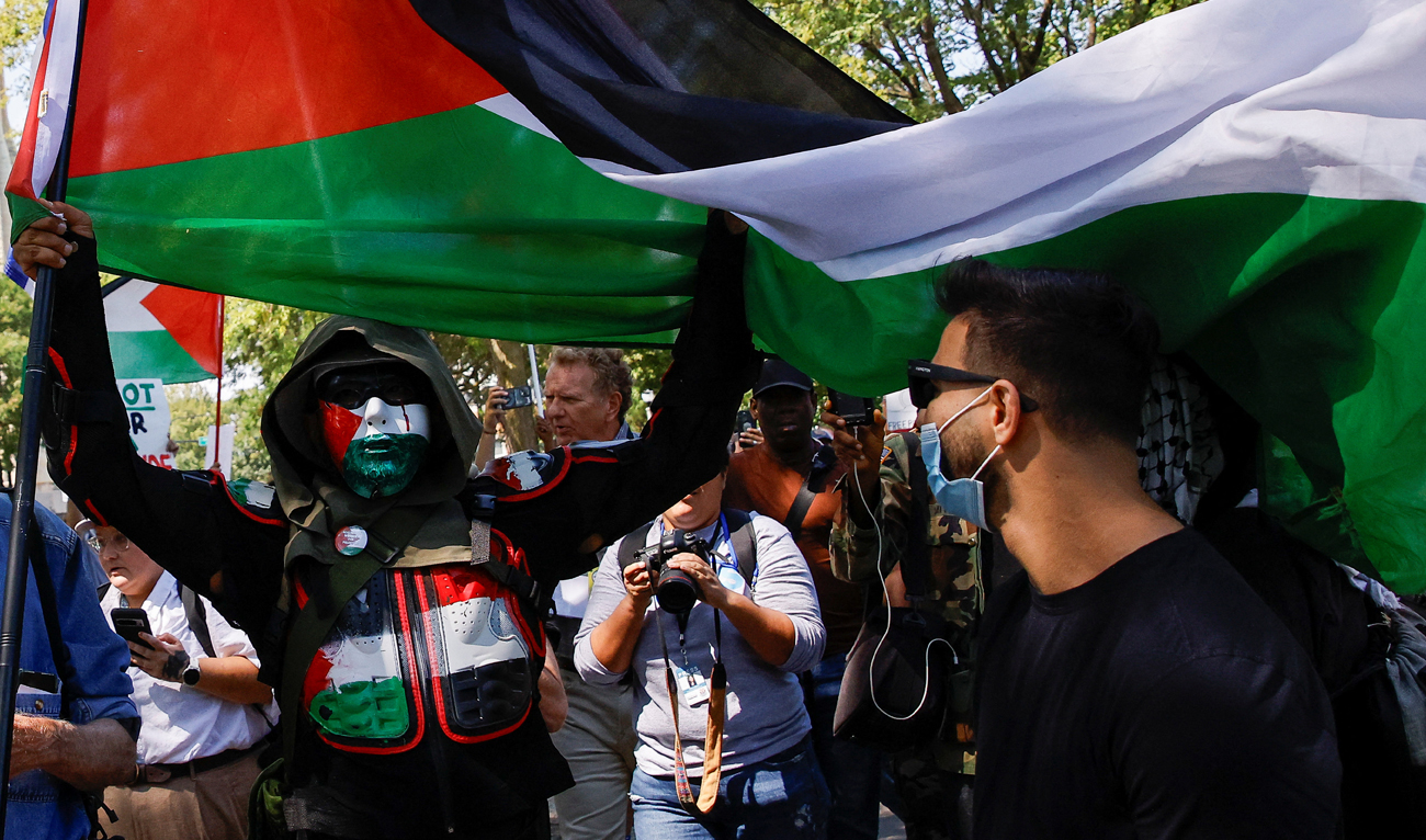 A person holds a flag in support of Palestinians in Gaza as demonstrators rally on the sidelines of the Democratic National Convention (DNC) in Chicago, Illinois, US on August 19, 2024. (REUTERS)