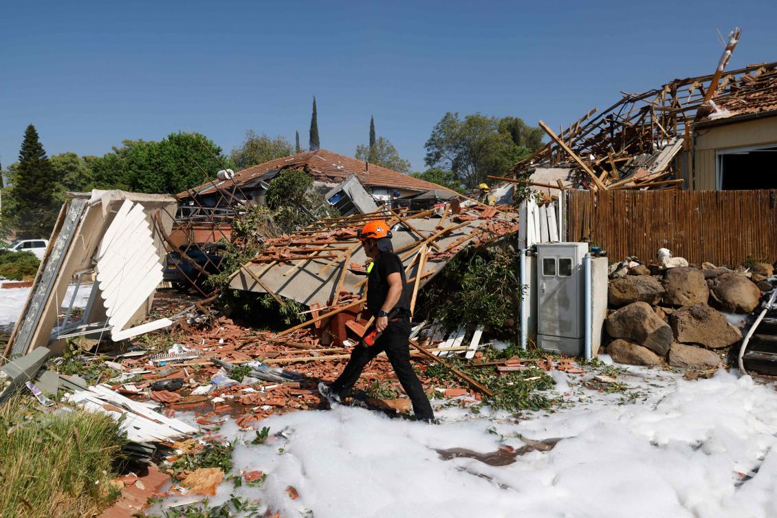 A firefighter inspects the damage at the site of a rocket attack, launched from southern Lebanon, in the town of Katzrin in the Israel-annexed Golan Heights on August 21, 2024, amid ongoing cross-border clashes between Israeli troops and Hezbollah fighters. (AFP)