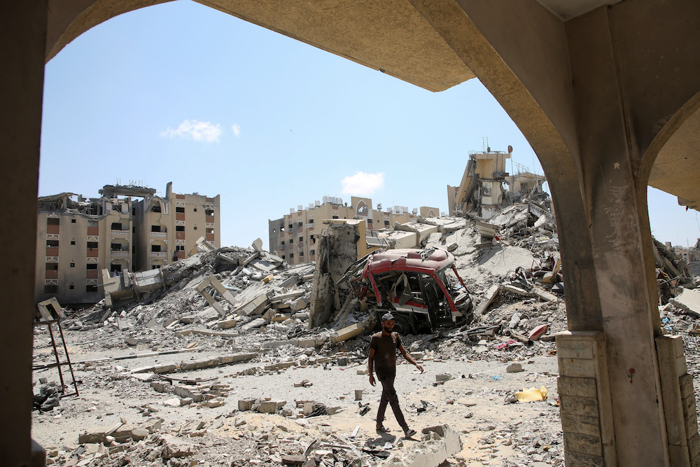 A Palestinian inspects damage in Qatari-funded Hamad City, following an Israeli raid, amid the ongoing conflict between Israel and Hamas, in Khan Younis, in the southern Gaza Strip, August 24, 2024. (Reuters)