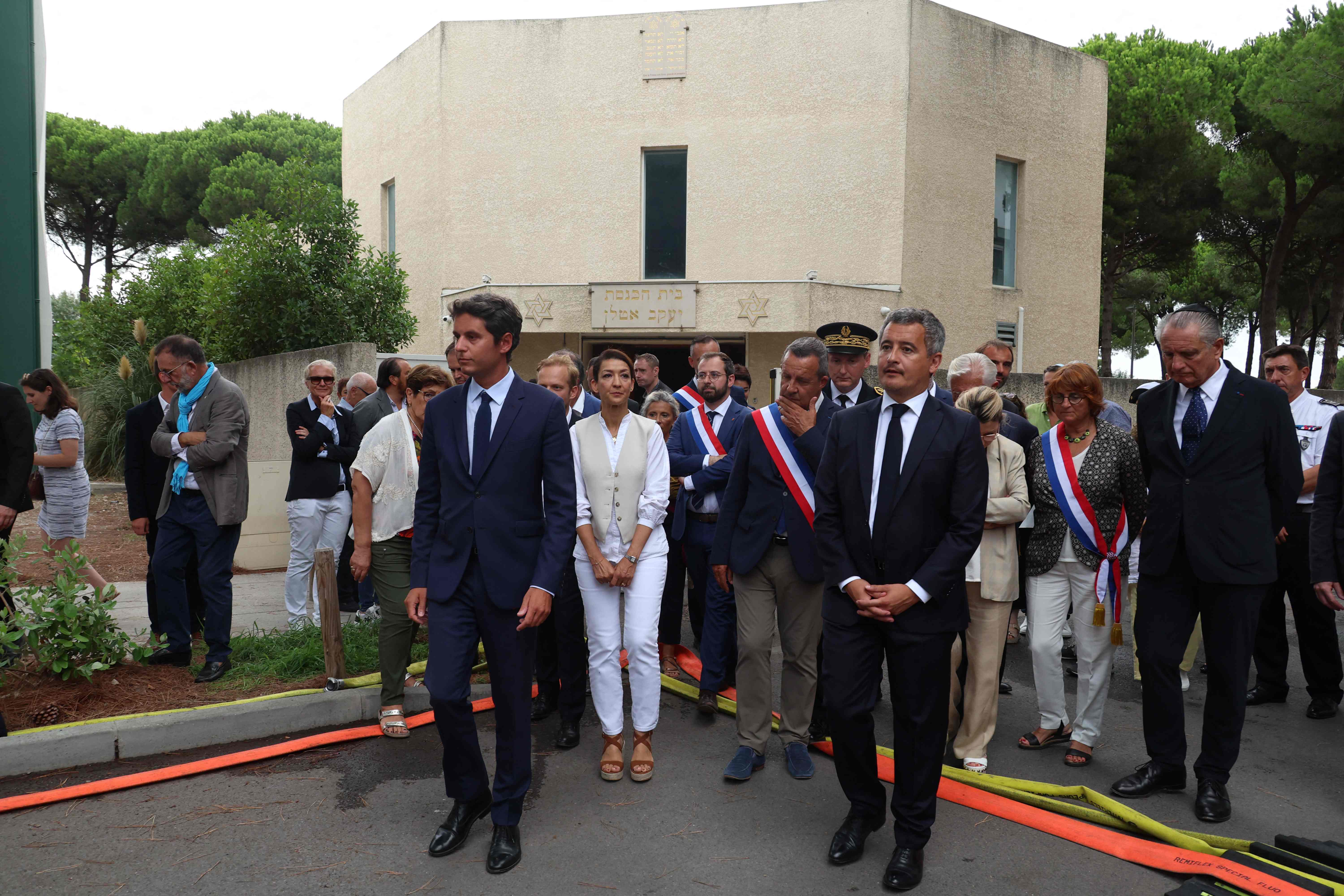 France’s Prime Minister, Gabriel Attal (L) and France’s Minister for the Interior and Overseas, Gerald Darmanin (R) flanked by France’s Secretary of State for Citizenship Sabrina Agresti-Roubache (C) exit the synagogue which was set on fire and were an explosion of cars occured in La Grande-Motte, south of France, on August 24, 2024. (AFP)