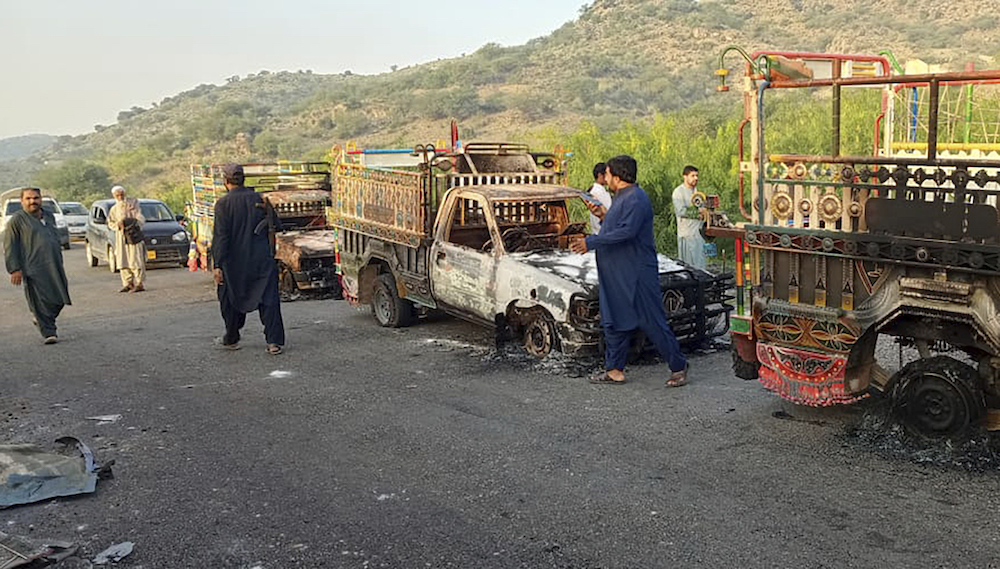 People look burnt vehicles, torched by gunmen after killing passengers, at a highway in Musakhail, a district in Baluchistan province in southwestern Pakistan on Aug. 26, 2024. (AP)