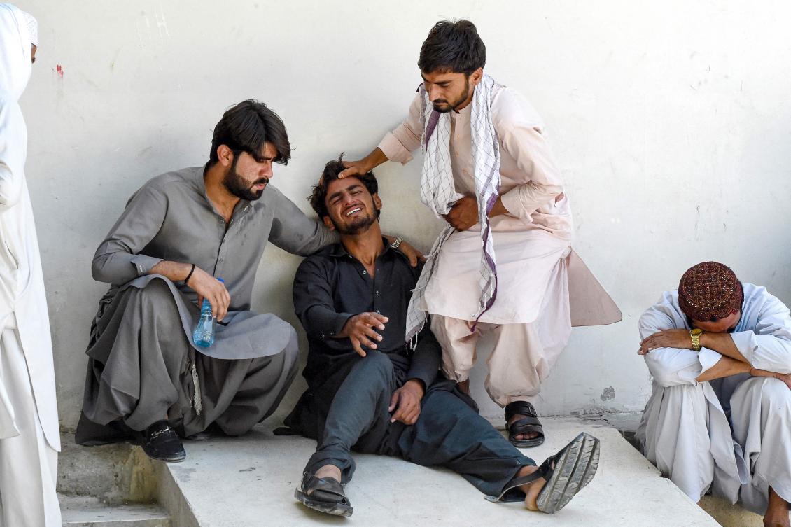 A man (2L) mourns the death of his father, who died in a separatist militants shooting, at a hospital in Quetta on August 26, 2024 (AFP)