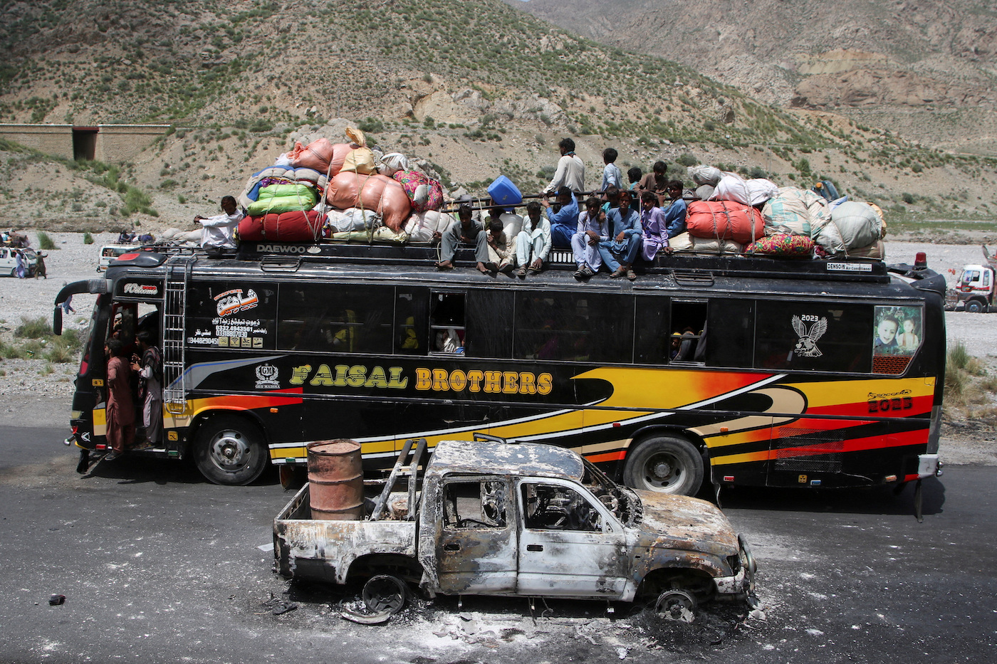 A bus drives past a damaged vehicle, a day after separatist militants conducted deadly attacks, in Bolan district of Pakistan’s restive province of Balochistan, August 27, 2024. (Reuters)