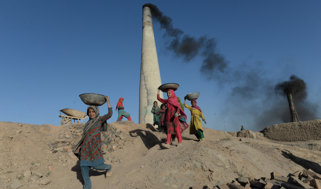 Afghan children carry coal collected from a brick factory on the outskirts of Kabul on June 1, 2018. (AFP)