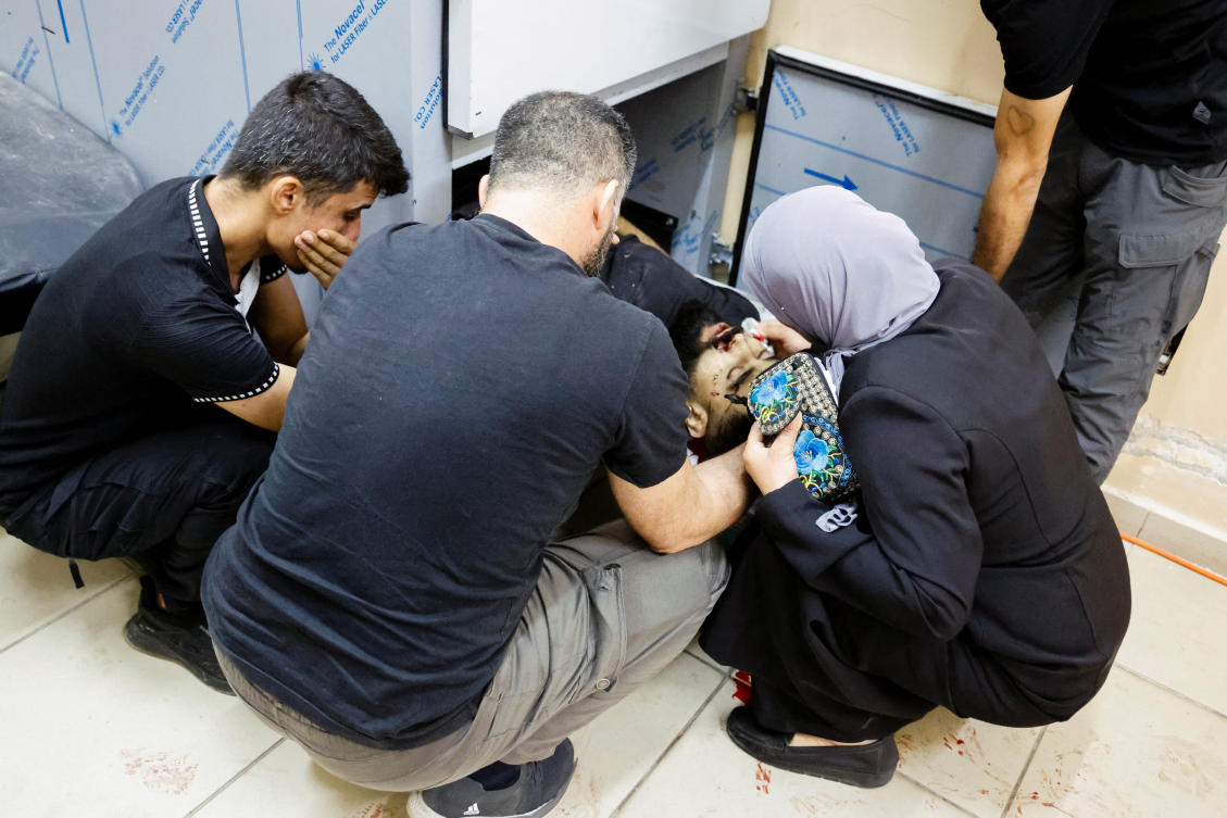 People mourn next to the body of a Palestinian killed in an Israeli air strike on a car, at a morgue in Tubas, in the Israeli-occupied West Bank, August 28, 2024. (REUTERS)
