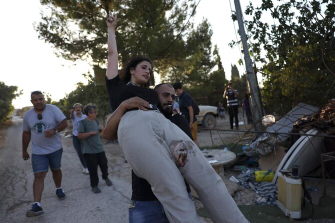 An injured activist bitten by a settler’s dog is evacuated as activists confront settlers in Al-Makhrour in the occupied West Bank near Beit Jala, south of Jerusalem, on August 22, 2024. (AFP)