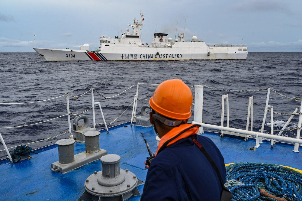 The Philippine coast guard has accused China of building an artificial island at Sabina Shoal, while China has said ‘illegal’ beaching by Philippine warships at the Spratly Islands. Above, a China coast guard ship as seen from a Philippine coast guard vessel in disputed waters of the South China Sea on Aug. 26, 2024. (AFP)