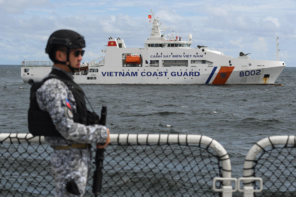 A Philippine Coast Guard personnel stands guard aboard the Gabriela Silang ship as a Vietnamese Coast Guard ship sails past during a joint maritime exercise off Bataan in the disputed South China Sea on Aug. 9, 2024. (AFP)